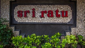 Un letrero con la palabra 'siriatu' en una pared con textura.