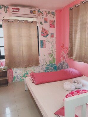 A bedroom with a bed, a window with curtains, a wall-mounted air conditioner, and a shelf with a box. - 1Sabai Hostel (Bangkok)