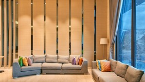 A modern living room with two sofas, a wooden partition, and a large window. - The Fuli Resort Chihpen (Taitung)