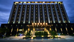 A multi-story hotel with a prominent entrance and illuminated signage. - The Fuli Resort Chihpen (Taitung)