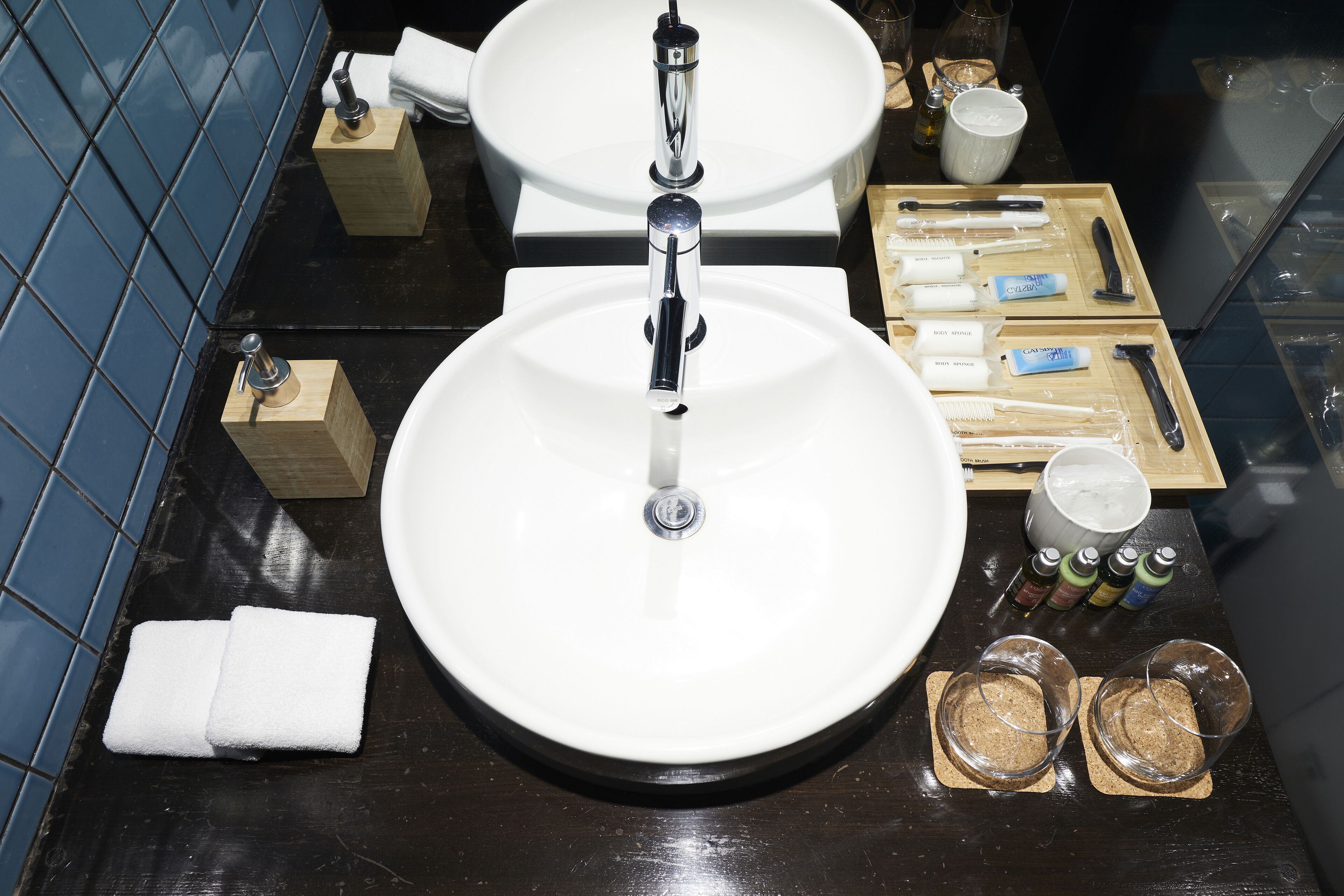 A bathroom with a white sink, a toilet, and a tray with toiletries.