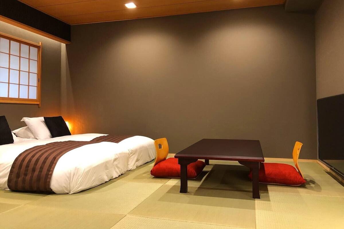 A room with a bed, a table, and chairs.