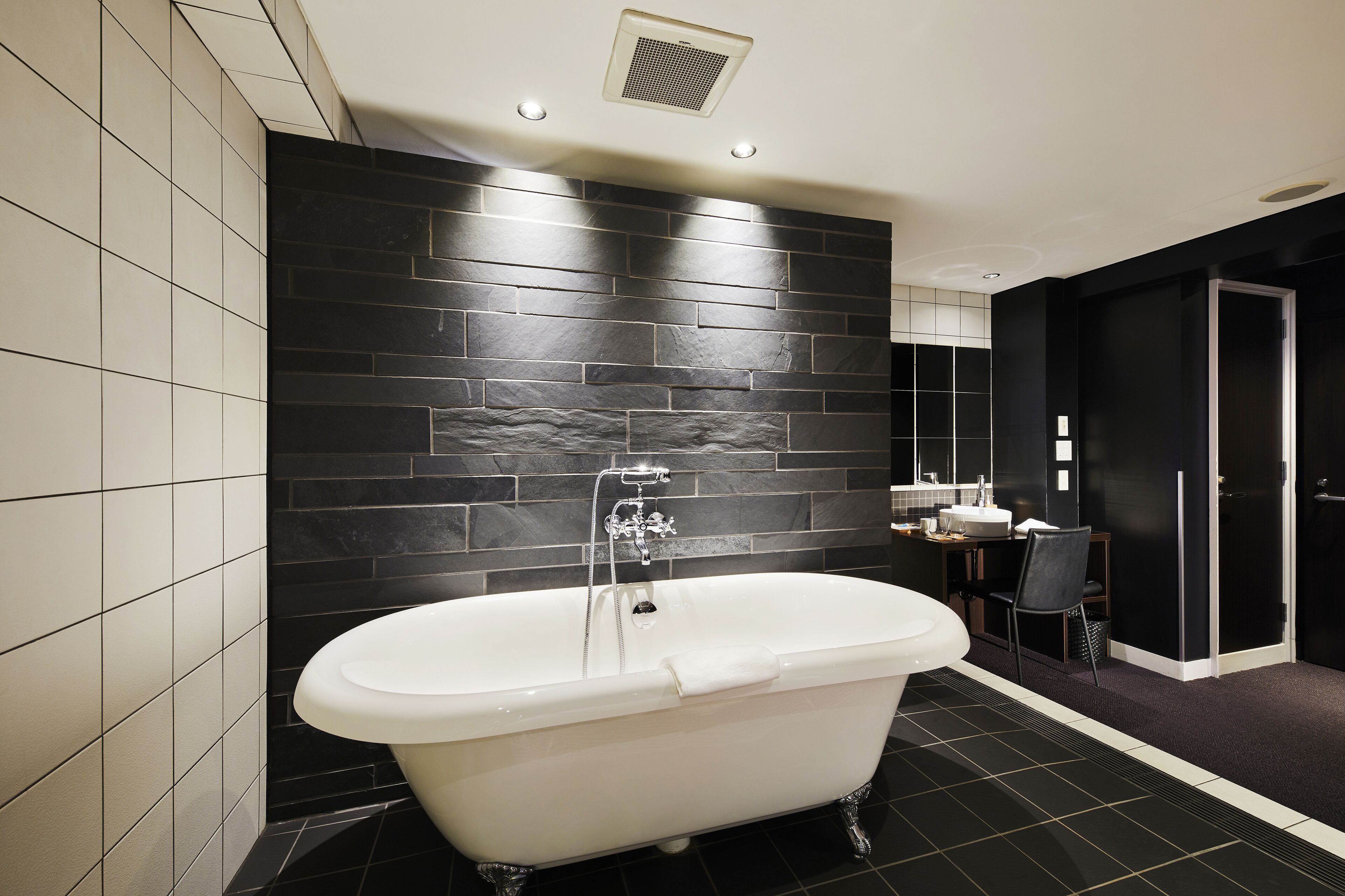 A modern bathroom with a freestanding bathtub, a sink, and a mirror.