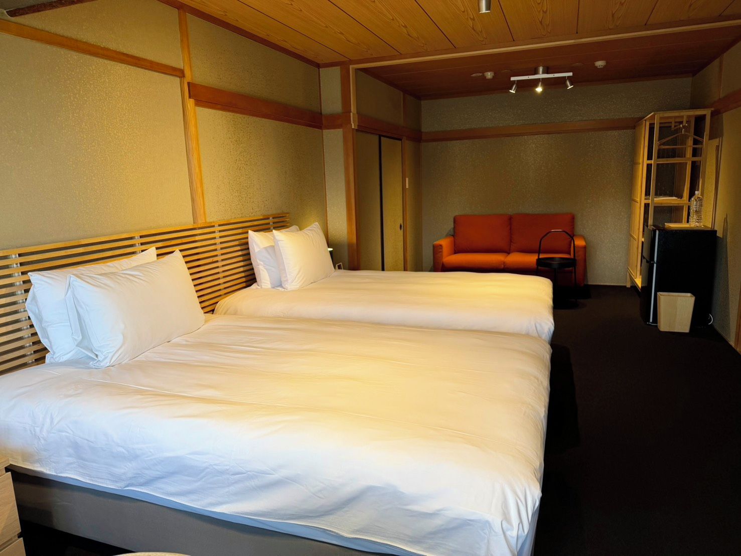 Una habitación de hotel con dos camas, un sofá y una pequeña mesa.