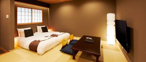 Habitación de hotel con cama, escritorio, silla, televisor y ventana con vistas.