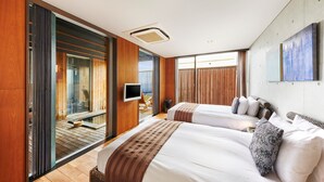 Une chambre d’hôtel moderne avec deux lits, une télévision et un balcon offrant une vue agréable.
