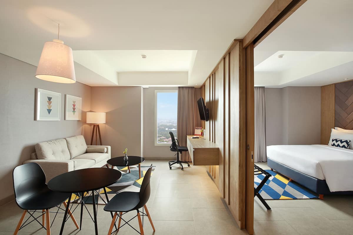 Une chambre d’hôtel comprenant un lit, un bureau, un canapé et un coin repas.