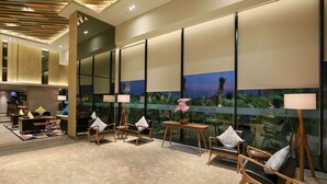 A modern lobby with a seating area, large windows, and a view of the outdoors.