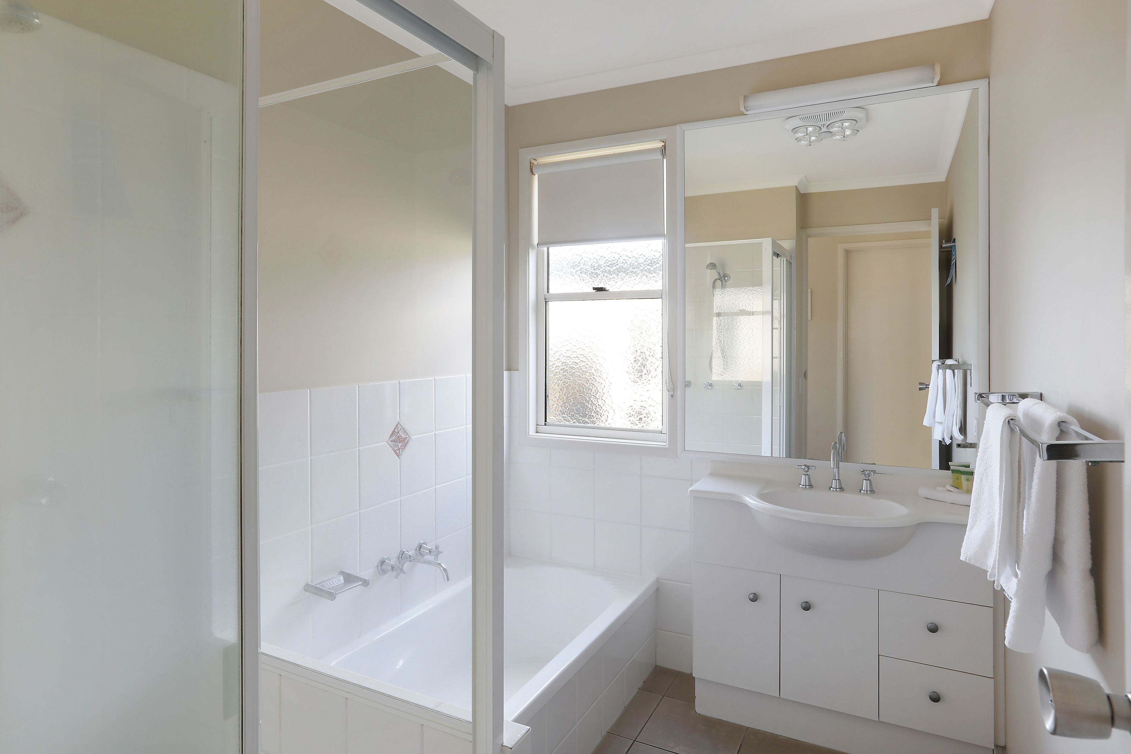 A modern bathroom with a bathtub, a sink, and a mirror.