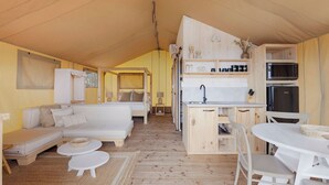 A compact, modern room with a sofa, a small dining table, and a kitchenette area. - Reflections Bonny Hills - Holiday Park (Bonny Hills)
