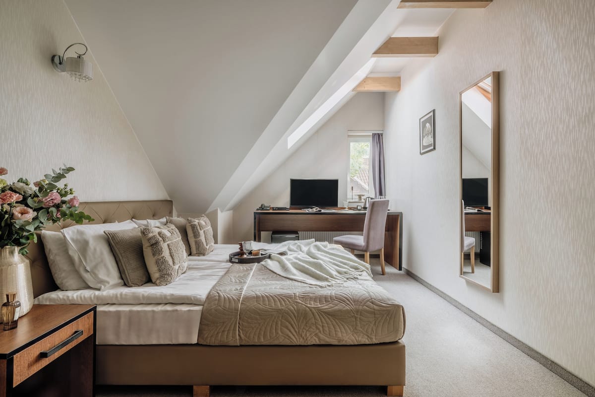 A bedroom with a bed, bedside table, and a desk with a chair.