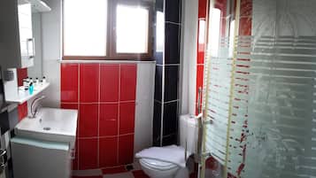 Suíte standard | Banheiro | Chuveiro, produtos de toalete grátis, chinelos