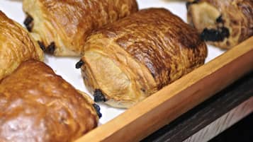 A tray of assorted pastries, including croissants and chocolate-filled pastries.