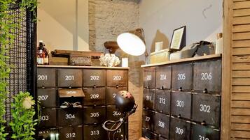 A room with a vintage bicycle, a wall-mounted number box, and a small shelf with various items.