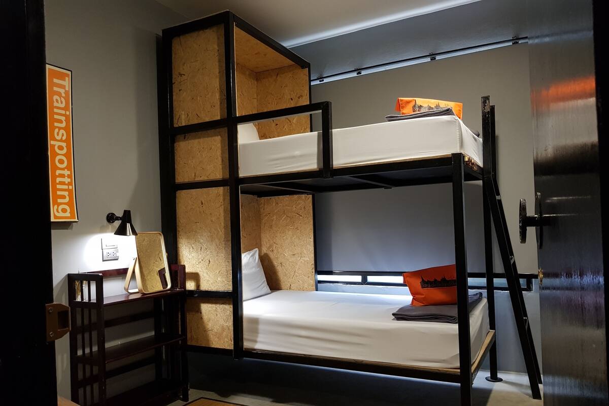 A bunk bed room with a desk, chair, and a sign that reads "Transporting".