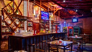A bar with wooden shelves, a neon sign, and various liquor bottles. - Wet Water Resort (Gampaha)