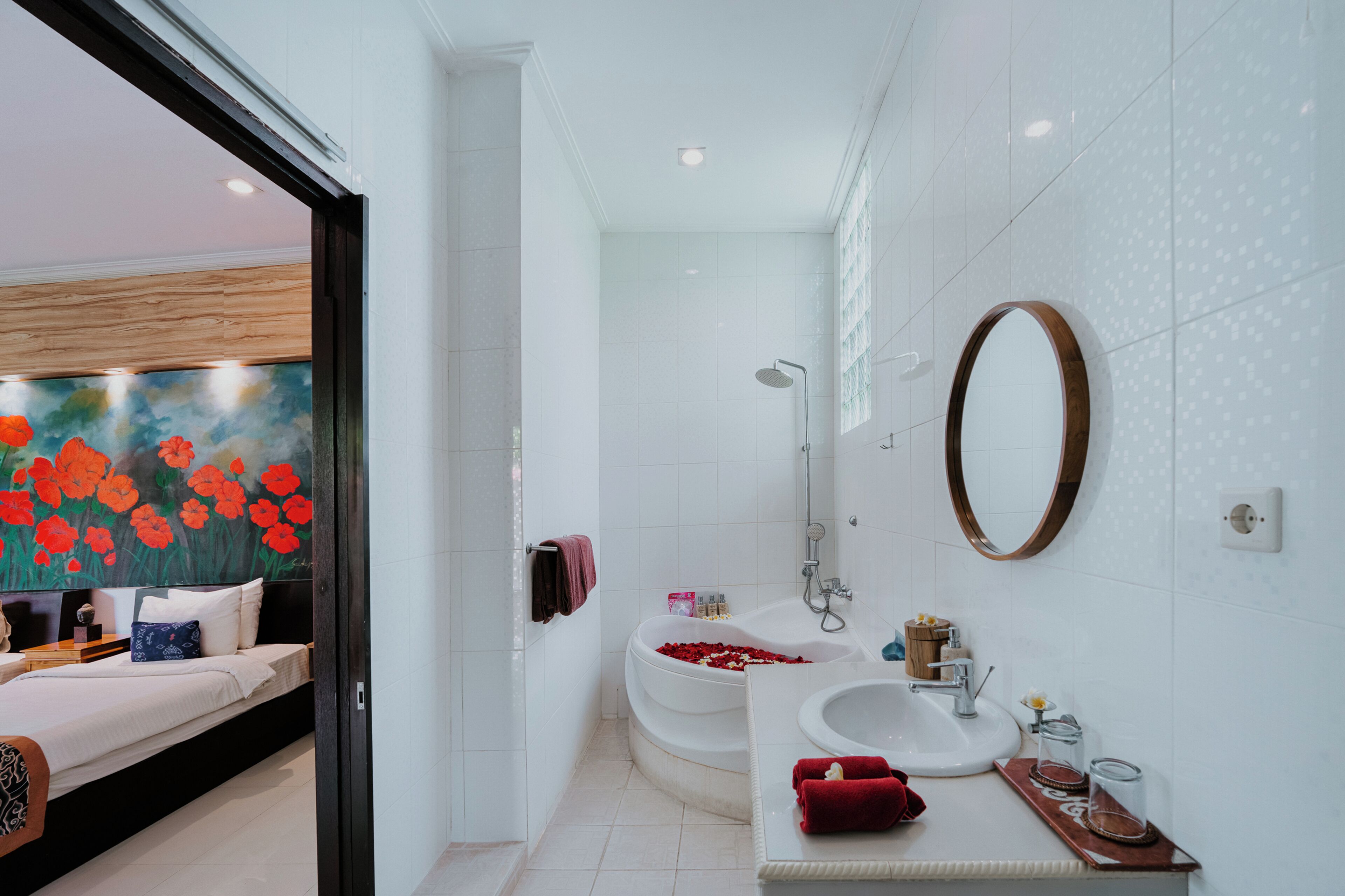Un baño moderno con bañera, lavabo y un espejo grande.