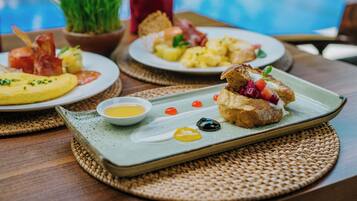 A dining table with plates of food, including toast with fruit and a small bowl of sauce.