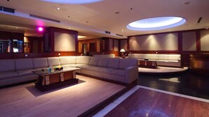 A spacious, modern lounge area with a curved ceiling and recessed lighting.