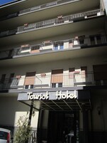 A multi-story building with balconies and a sign that reads "Tourist Hotel".