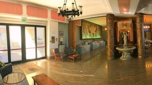 A spacious lobby with a central fountain, seating areas, and large windows with decorative glass. - Tourist Hotel (Potenza)