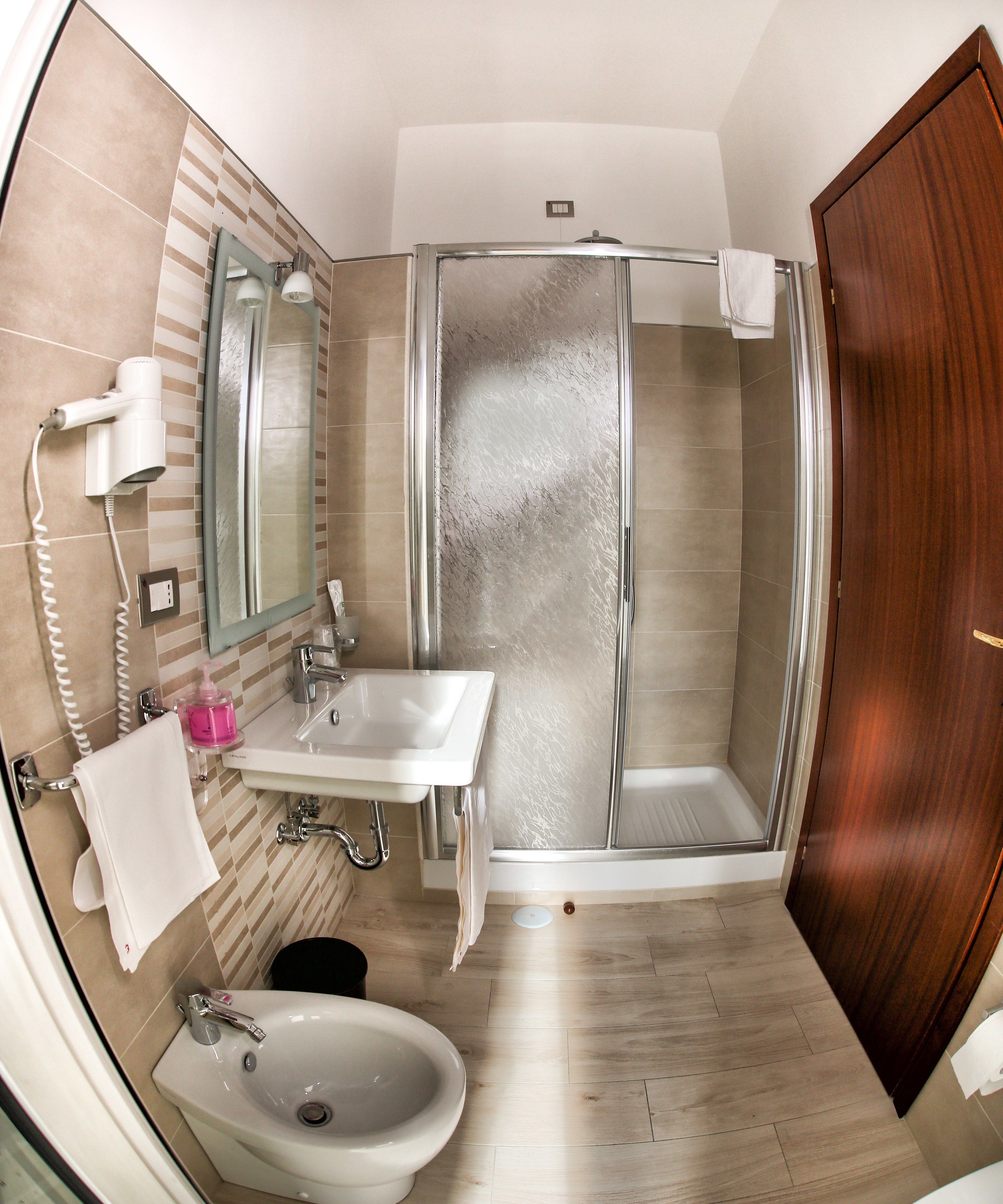 A bathroom with a shower, sink, and toilet.