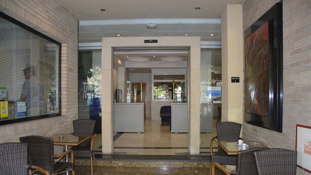 A hotel lobby with wicker furniture, a glass coffee table, and a tiled floor. - Hotel Casa Emilio (Murcia)