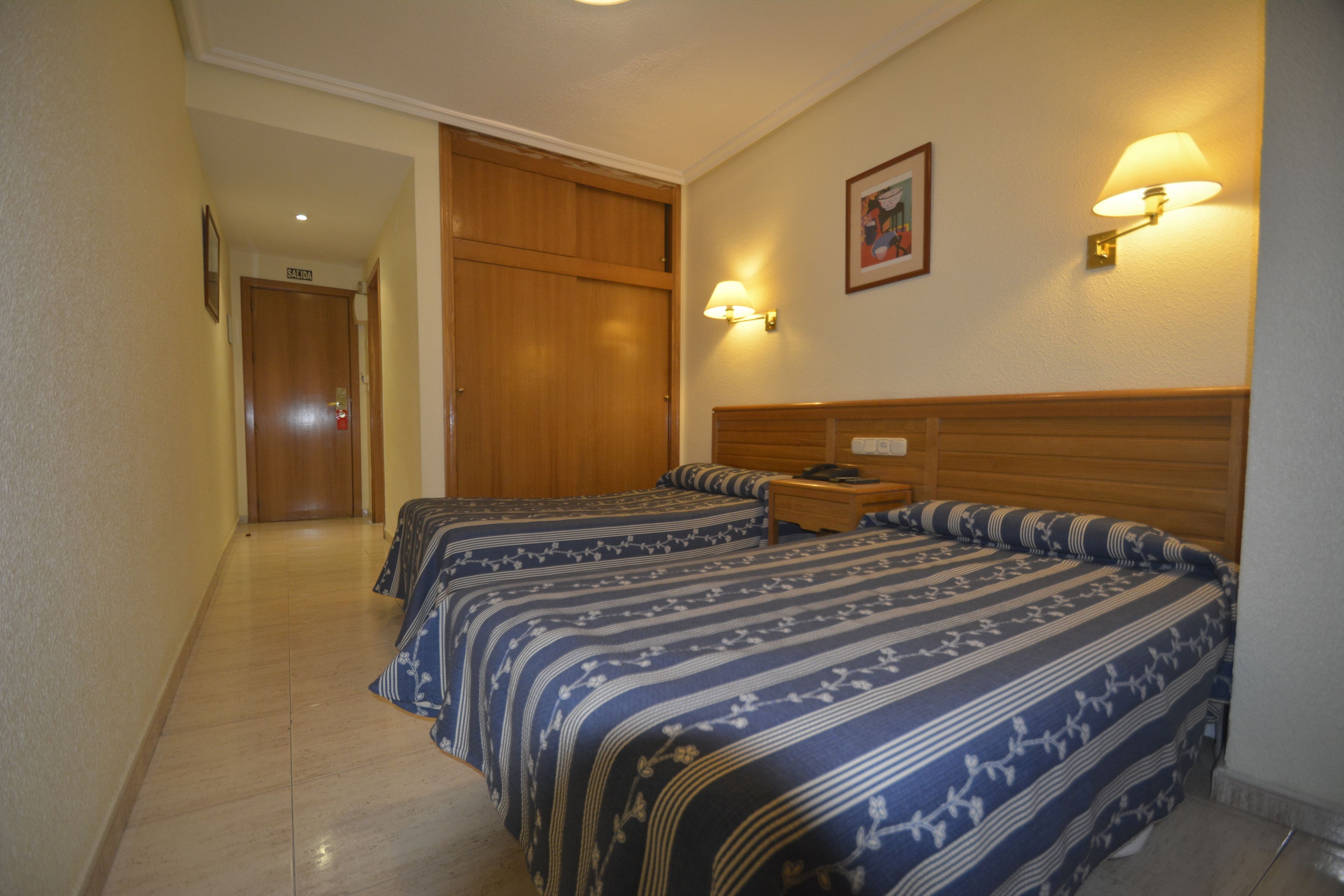 Escritorio, cortinas opacas, tabla de planchar con plancha