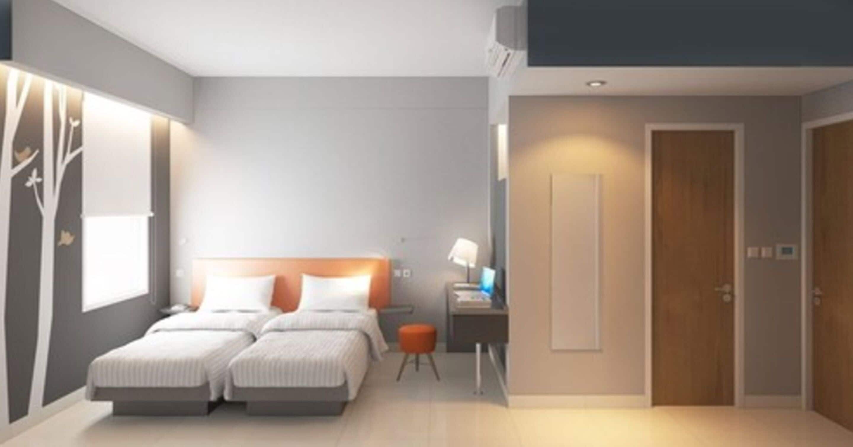 A modern hotel room with two single beds, a desk with a chair, a small table, and a wardrobe.