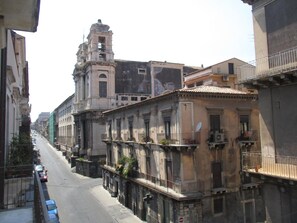 A narrow street lined with historic buildings, including a prominent church tower. - B&B Bella Stella (Catania)