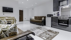 A modern apartment with a living room, kitchenette, and a flat-screen TV mounted on the wall. - City Gate Serviced Apartments (London)