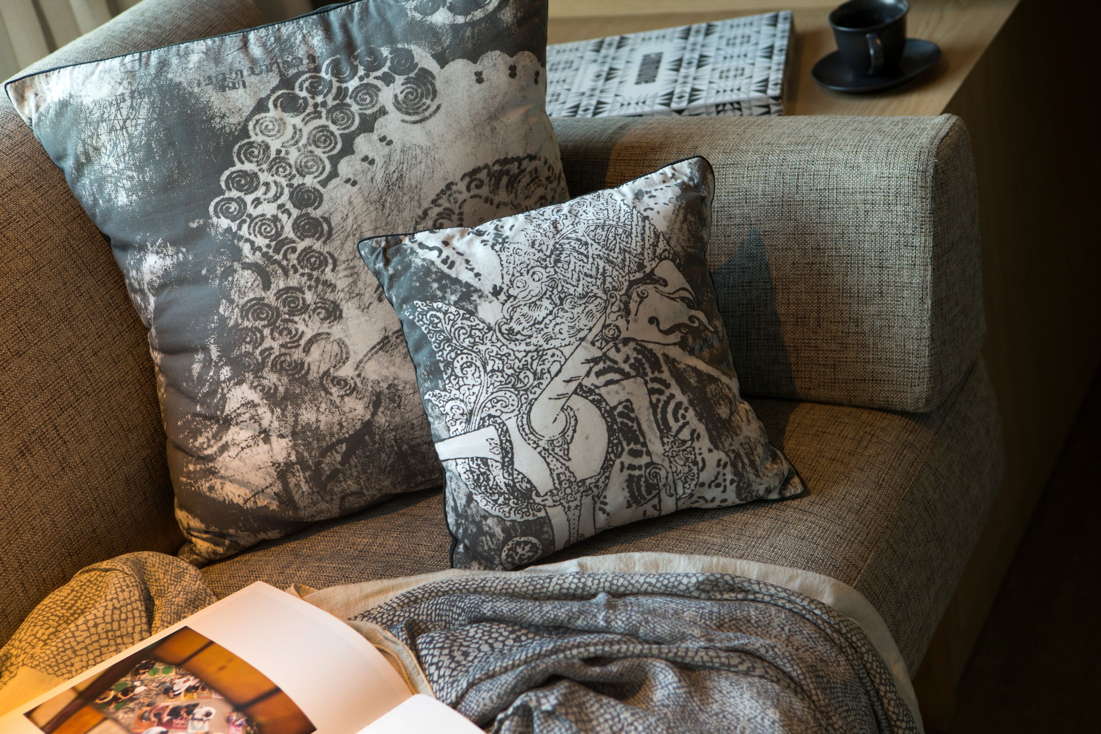 A sofa with patterned cushions and a blanket.