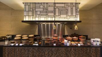 A buffet setup with various dishes and utensils.