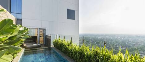 A modern building with a swimming pool and a view of a cityscape.