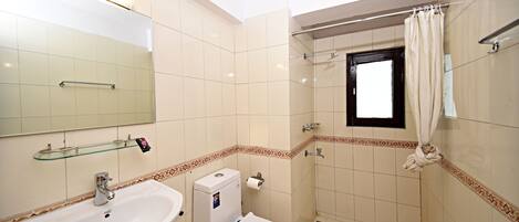 A bathroom with a sink, toilet, and shower.
