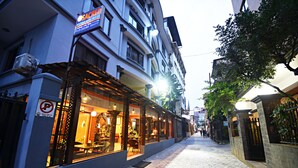 Um hotel com área de estar coberta ao ar livre e grandes janelas.