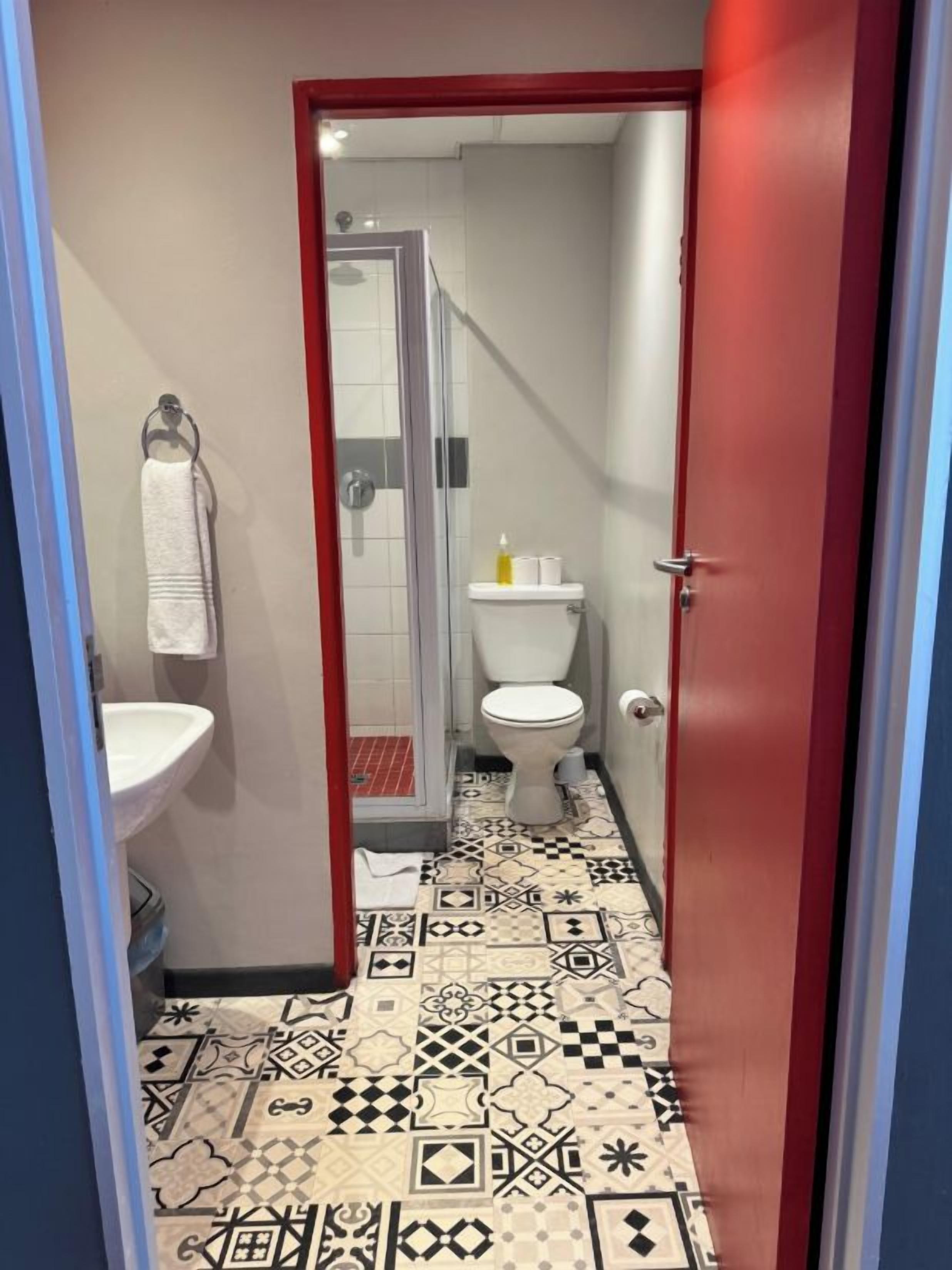 A bathroom with a patterned floor, a white sink, and a toilet.