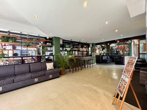 A spacious cafe interior with a bar area, seating, and a display board. - 91 Loop - Hostel (Cape Town)