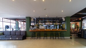 A bar area with stools, a counter, and shelves with bottles. - 91 Loop - Hostel (Cape Town)