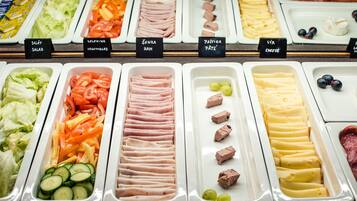 En buffé med ett varierat utbud av mat, inklusive sallader, grönsaker, skinka, paté, ost och kött.