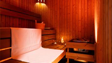 A wooden sauna room with benches and a bench with a towel.