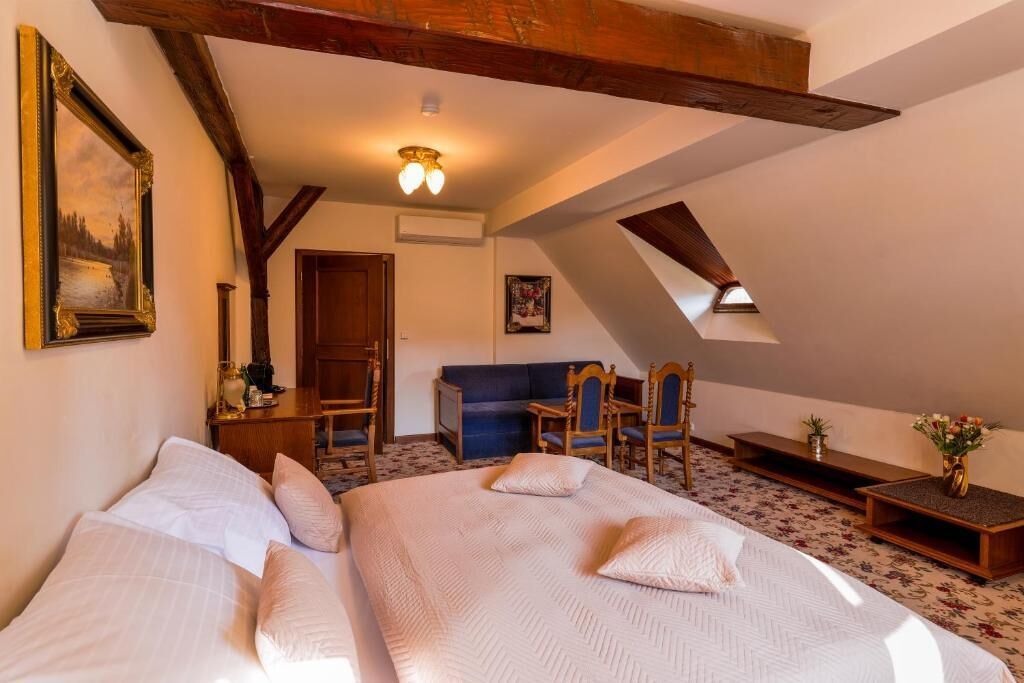 Un dormitorio con dos camas, muebles de madera, un escritorio y una silla.