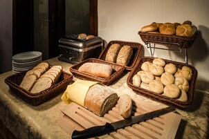 Una mesa con distintos tipos de pan y una tostadora.