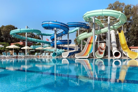 A water park with multiple slides and a swimming pool.