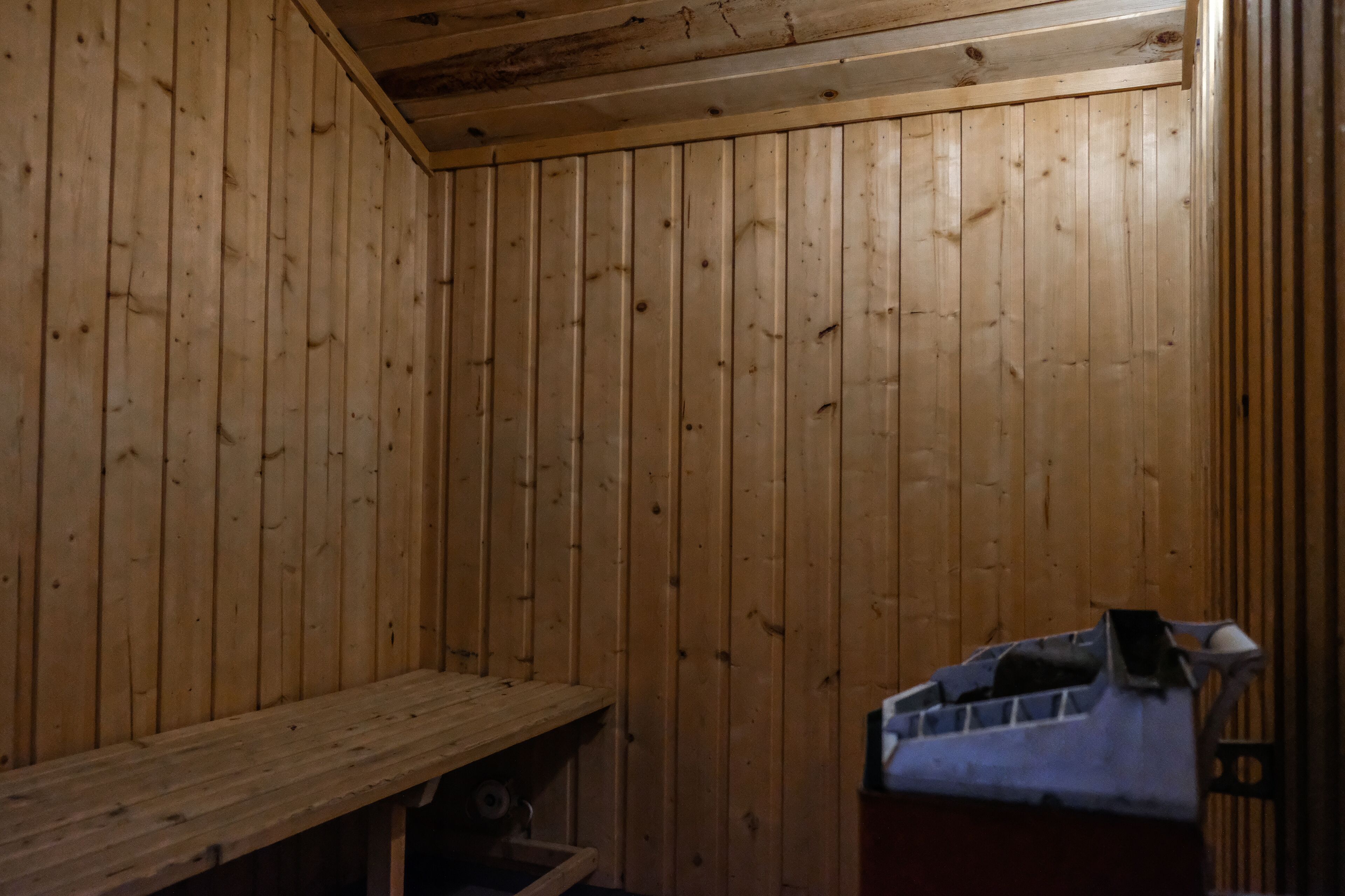 A wooden cabin interior with a bench and a small table.