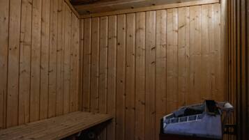 A wooden cabin interior with a bench and a small table.