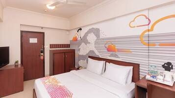 Une chambre d’hôtel équipée d’un lit, d’un bureau avec un téléphone, d’une machine à café et d’un mur orné d’un motif graphique.
