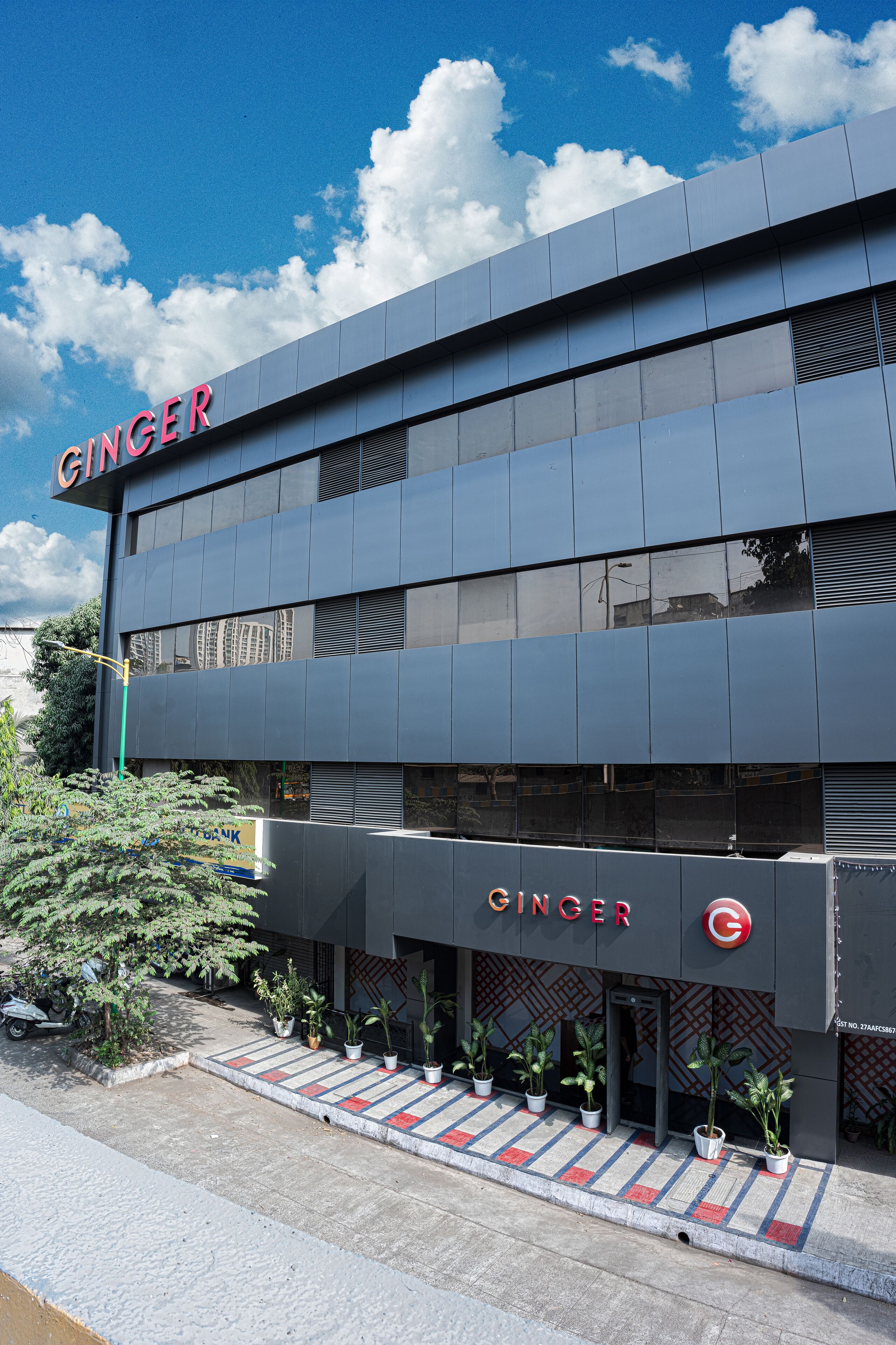 A building with the name "GINGER" on the facade, featuring a modern architectural style with a flat roof and large windows.