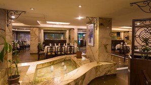 A lobby with a marble fountain, seating areas, and a reception desk. - Ginger Hotel Thane (Thane)