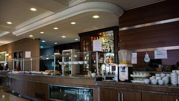 A buffet area with a variety of food items, a coffee station, and a beverage dispenser.